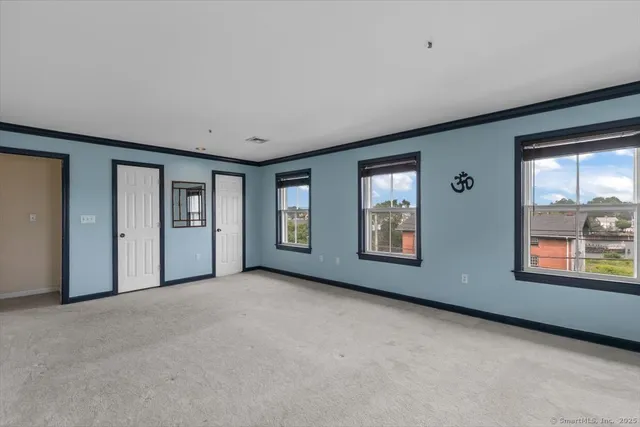 an empty room with windows and closet