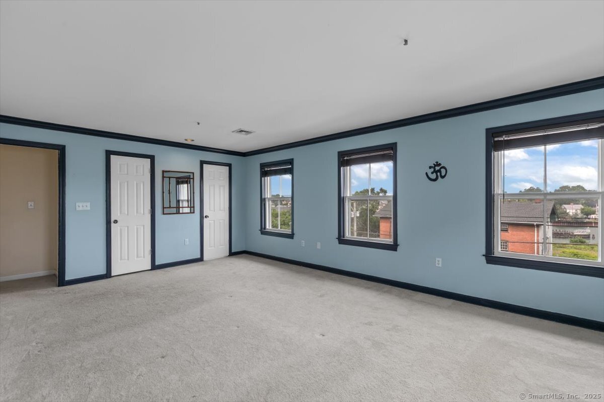 677 Quinnipiac Avenue, Unit 9 New Haven, CT 06513 - Photo 23 of 36 an empty room with windows and closet