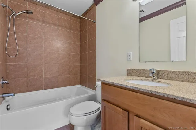 a bathroom with a granite countertop sink toilet and shower