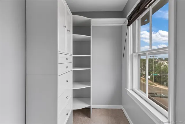 a view of walk in closet with empty racks