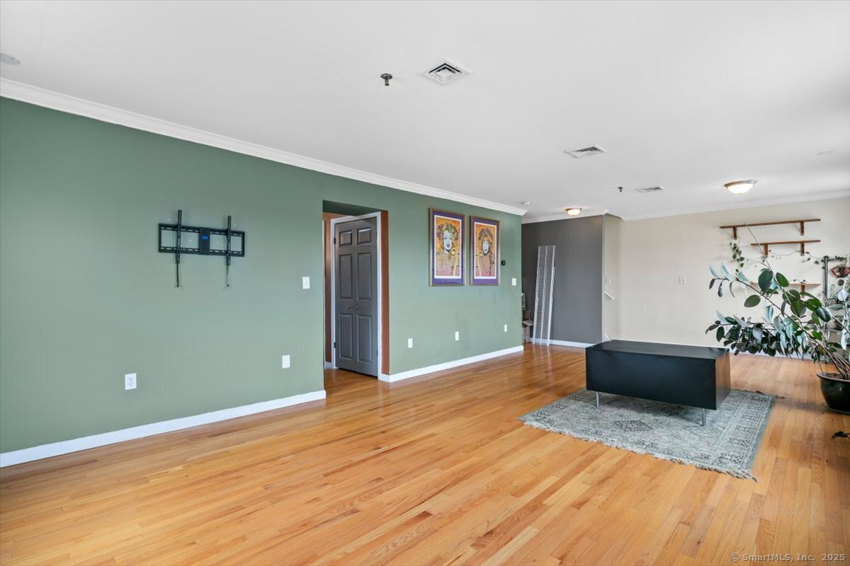 677 Quinnipiac Avenue, Unit 9 New Haven, CT 06513 - Photo 6 of 36 a view of an empty room with wooden floor and a potted plant