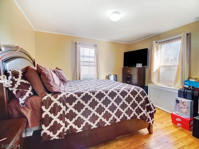 a bedroom with a large bed and a flat tv screen on dresser