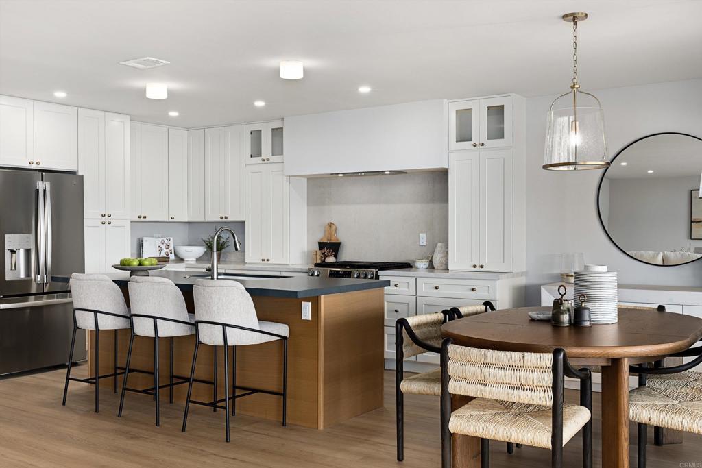 a kitchen with a dining table chairs refrigerator and cabinets