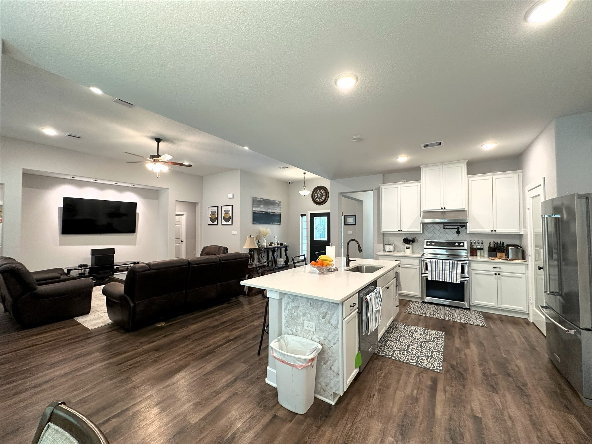 14144 Old Highway 59N Splendora, TX 77372 - Photo 17 of 24 a large living room with stainless steel appliances kitchen island granite countertop a refrigerator a stove a sink dishwasher and a dining table with wooden floor