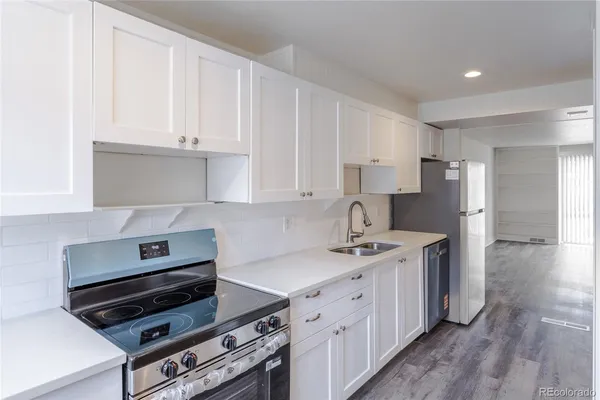 a kitchen with a stove a sink and a refrigerator