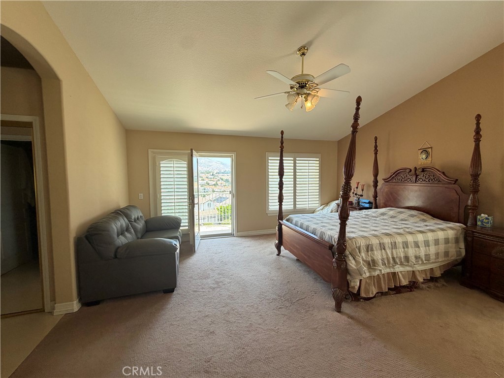 19823 Mariposa Pines Way Porter Ranch, CA 91326 - Photo 24 of 50 a bedroom with a bed couch and windows