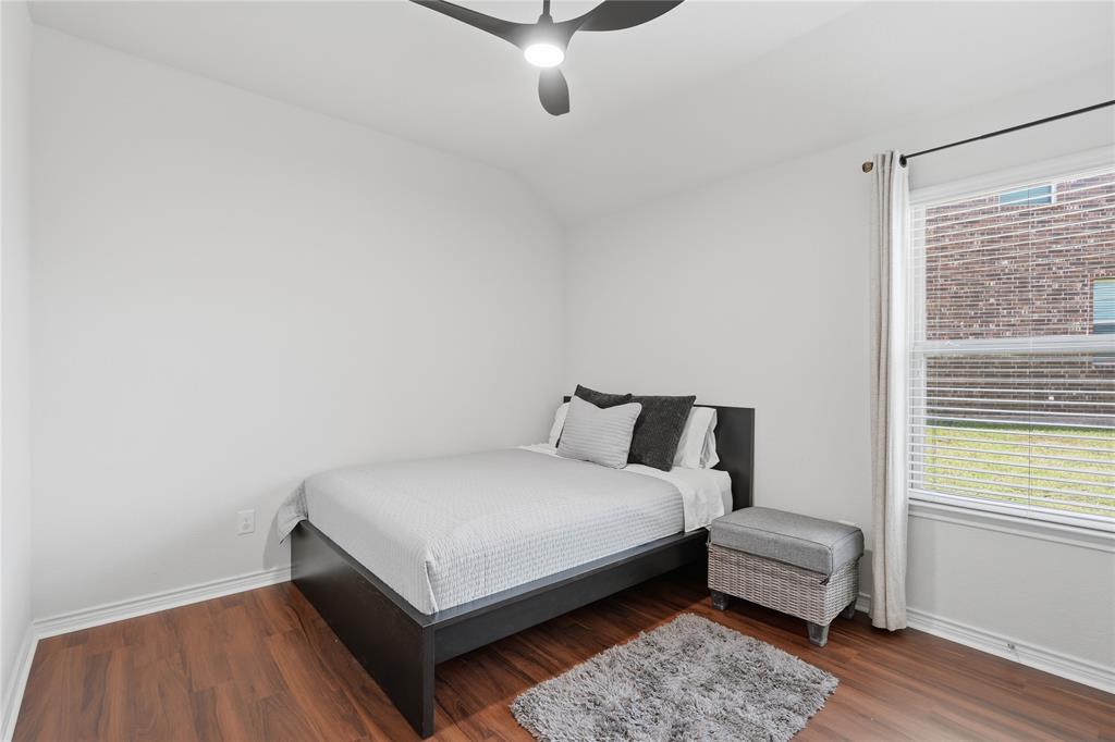 10101 Travis Road Little Elm, TX 75068 - Photo 10 of 26 a bedroom with a bed and wooden floor