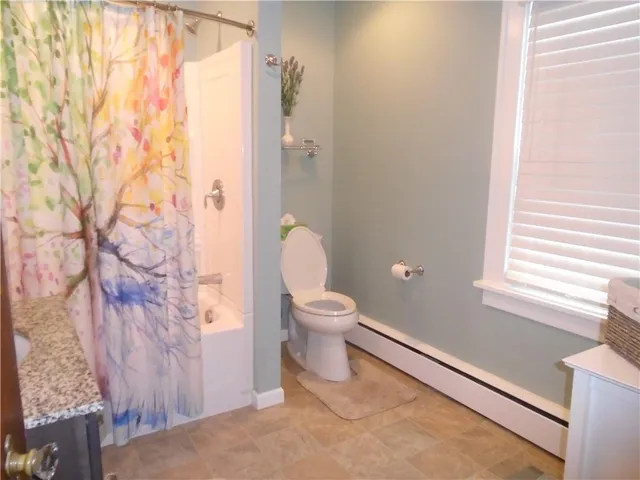 a bathroom with a granite countertop toilet and a shower