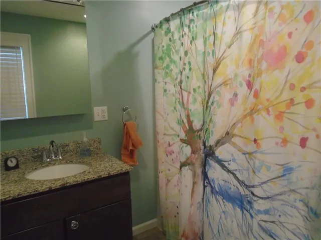 a bathroom with a granite countertop sink and a mirror