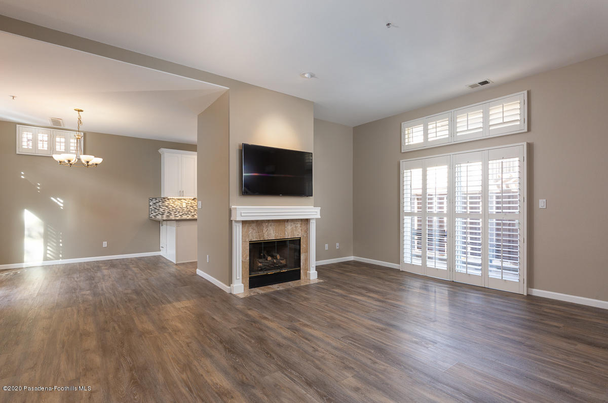 306 Alpine Street, Unit 3 Pasadena, CA 91106 - Photo 6 of 26 an empty room with windows a fireplace and wooden floor