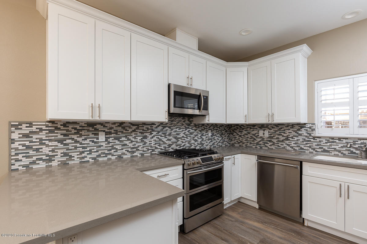 306 Alpine Street, Unit 3 Pasadena, CA 91106 - Photo 8 of 26 a kitchen with granite countertop white cabinets and stainless steel appliances