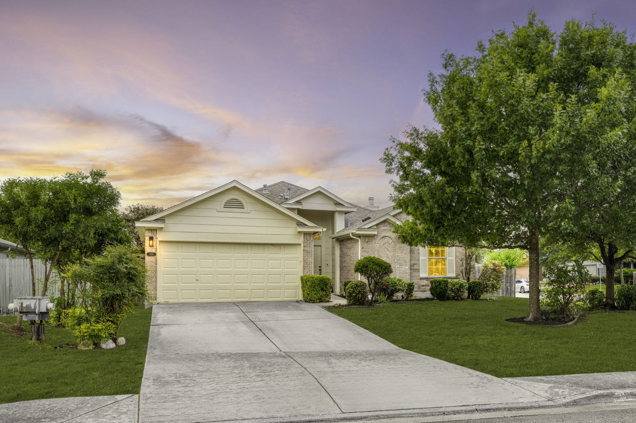 a front view of a house with a yard and trees