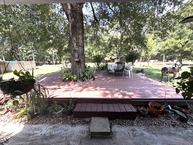 3080 Lee Turner Road Cleveland, TX 77328 - Photo 26 of 48 Expansive back patio surrounded by mature shade trees—an inviting outdoor space perfect for relaxing, entertaining, and enjoying the peaceful country setting.
