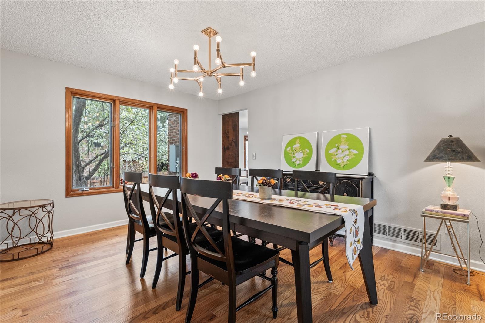4852 South Carson Street Aurora, CO 80015 - Photo 13 of 50 a view of a dining room with furniture a chandelier and wooden floor