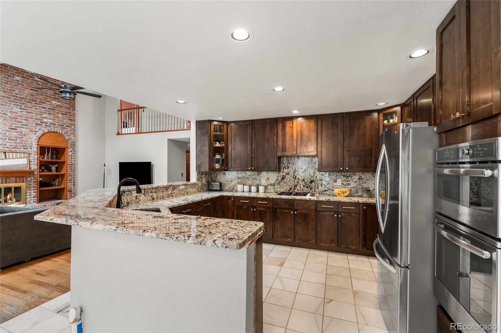 4852 South Carson Street Aurora, CO 80015 - Photo 15 of 50 a kitchen with stainless steel appliances granite countertop a sink stove and refrigerator