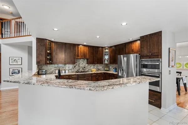 a large kitchen with granite countertop a large counter top stainless steel appliances and cabinets