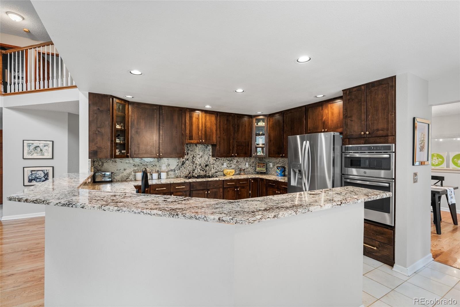 4852 South Carson Street Aurora, CO 80015 - Photo 16 of 50 a large kitchen with granite countertop a large counter top stainless steel appliances and cabinets