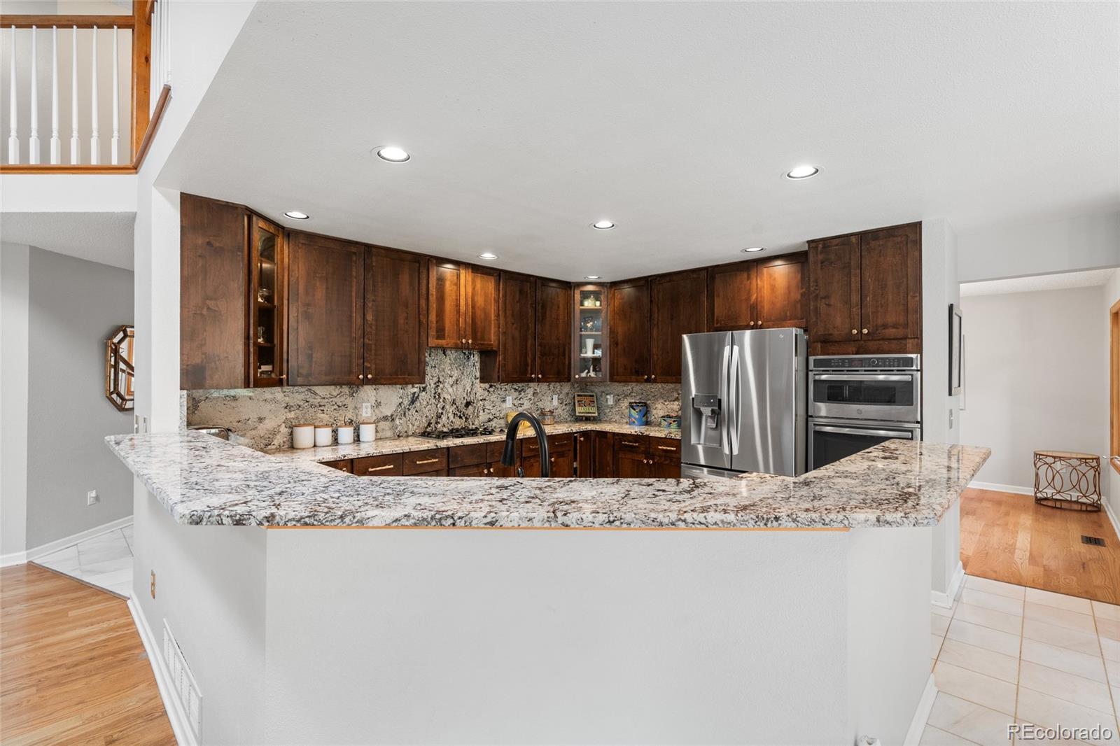 4852 South Carson Street Aurora, CO 80015 - Photo 17 of 50 a large kitchen with stainless steel appliances kitchen island a large counter top and a sink