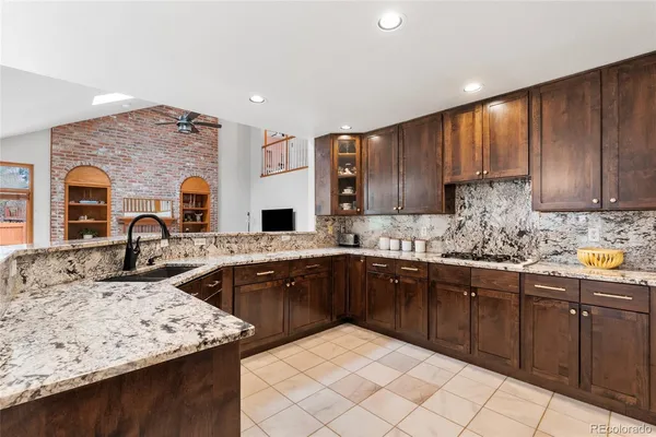 a kitchen with stainless steel appliances granite countertop a sink stove and cabinets