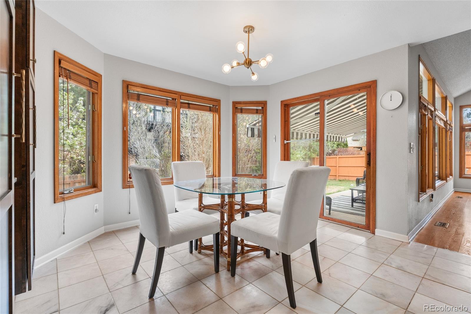4852 South Carson Street Aurora, CO 80015 - Photo 20 of 50 a view of a dining room with furniture large windows and wooden floor