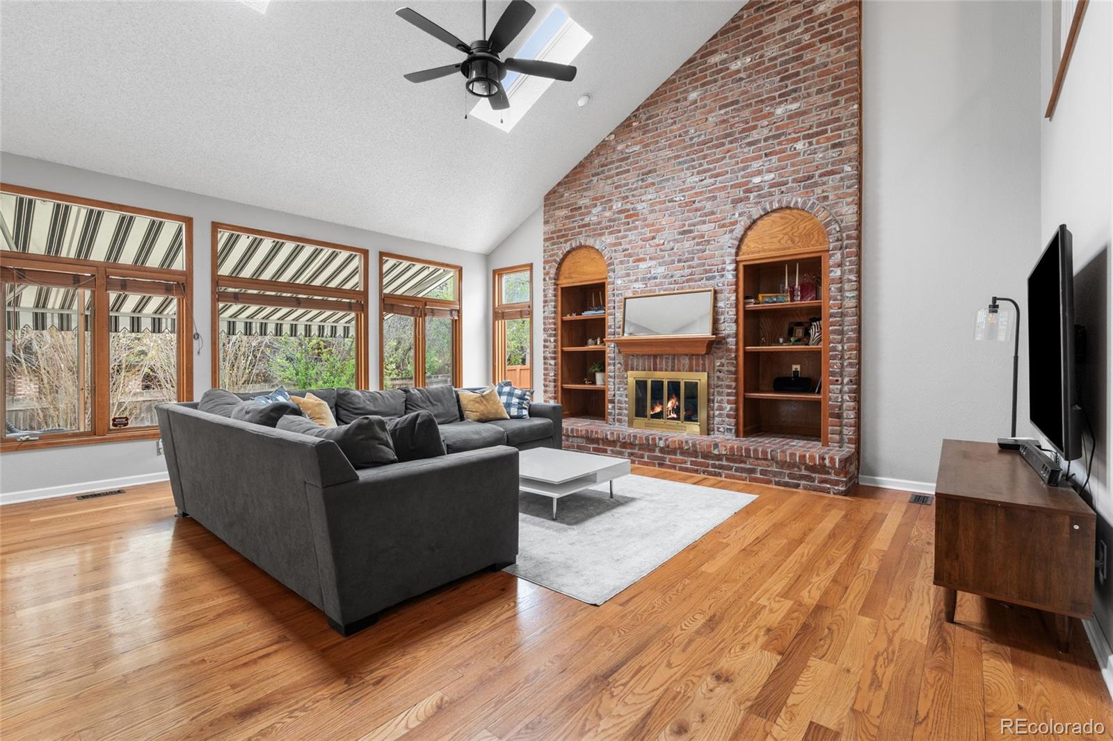 4852 South Carson Street Aurora, CO 80015 - Photo 26 of 50 a living room with furniture wooden floor and a flat screen tv