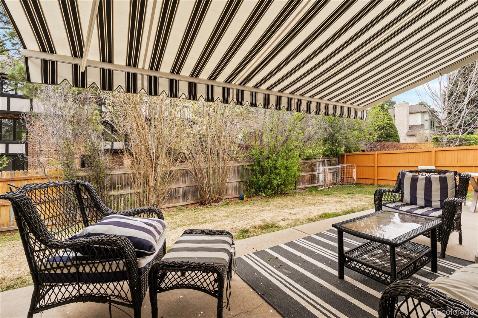 4852 South Carson Street Aurora, CO 80015 - Photo 48 of 50 a view of a patio with table and chairs with wooden floor and fence