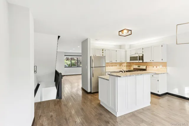 a kitchen with refrigerator cabinets and wooden floor