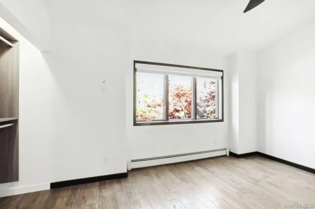 an empty room with wooden floor and window