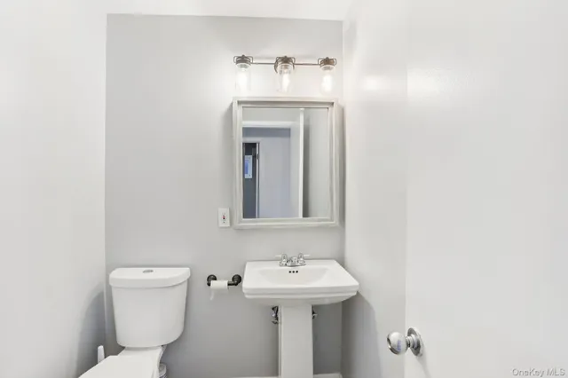 a bathroom with a sink a toilet and mirror