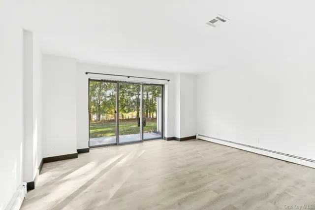 an empty room with floor to ceiling window and an outdoor view