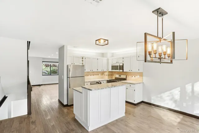 a kitchen with a sink a refrigerator and wooden floor