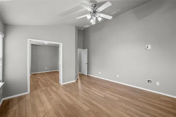 a view of an empty room with wooden floor