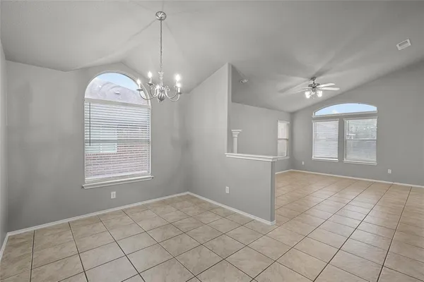 a view of a livingroom with chandelier fan and windows