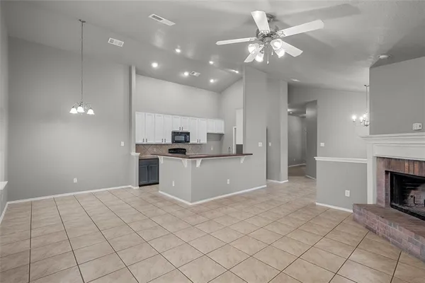a view of kitchen and empty room with windows