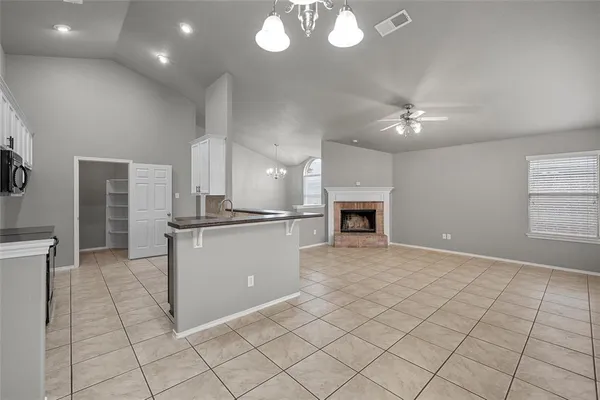 an empty room with kitchen and fireplace