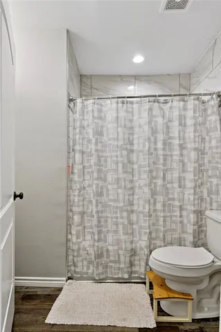 a bathroom with a toilet and a shower