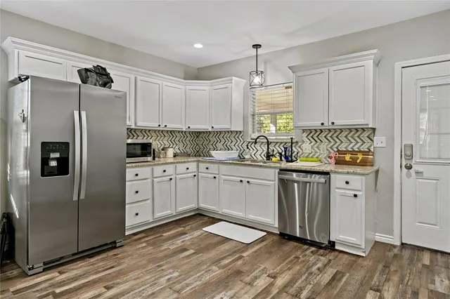 a kitchen with stainless steel appliances a refrigerator sink and cabinets
