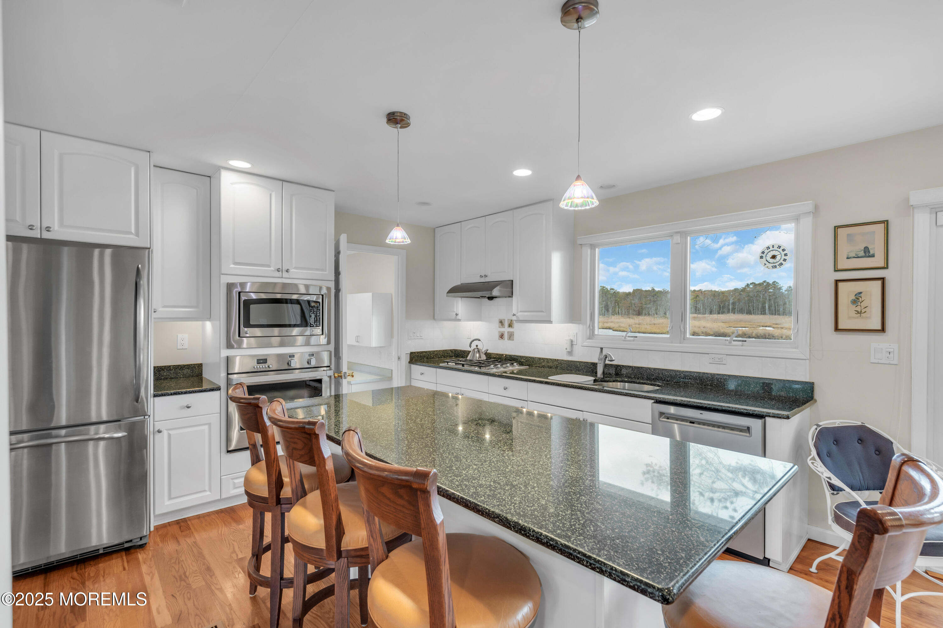 607 Ranger Drive Forked River, NJ 08731 - Photo 10 of 38 a kitchen with stainless steel appliances granite countertop a stove top oven a refrigerator a sink and chairs