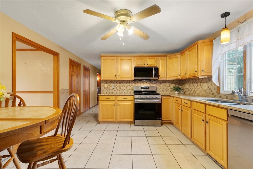 195 High Street Randolph, MA 02368 - Photo 15 of 42 a kitchen with stainless steel appliances a stove a sink cabinets and a dining table