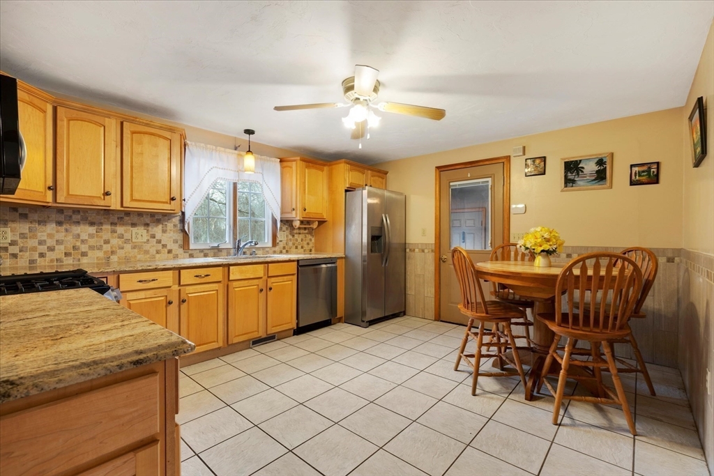 195 High Street Randolph, MA 02368 - Photo 16 of 42 a kitchen with granite countertop cabinets stainless steel appliances and a dining table