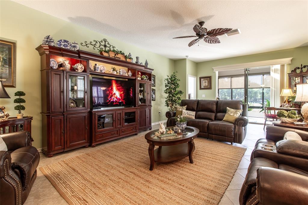 16123 Southwest 14th Avenue Road Ocala, FL 34473 - Photo 11 of 65 a living room with furniture a flat screen tv and a chandelier