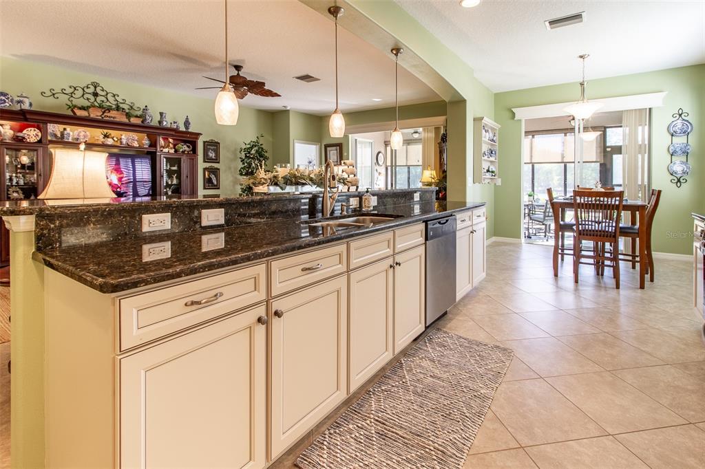 16123 Southwest 14th Avenue Road Ocala, FL 34473 - Photo 19 of 65 a kitchen with stainless steel appliances granite countertop a sink a stove top oven a counter space and cabinets