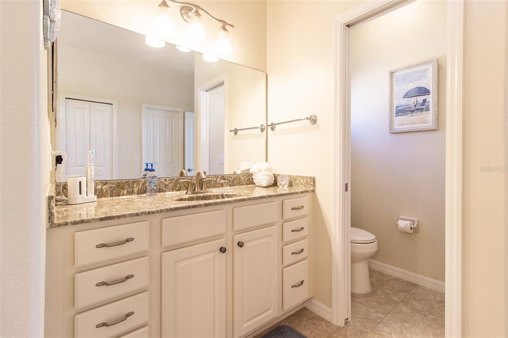 16123 Southwest 14th Avenue Road Ocala, FL 34473 - Photo 31 of 65 a bathroom with a granite countertop sink toilet and a mirror