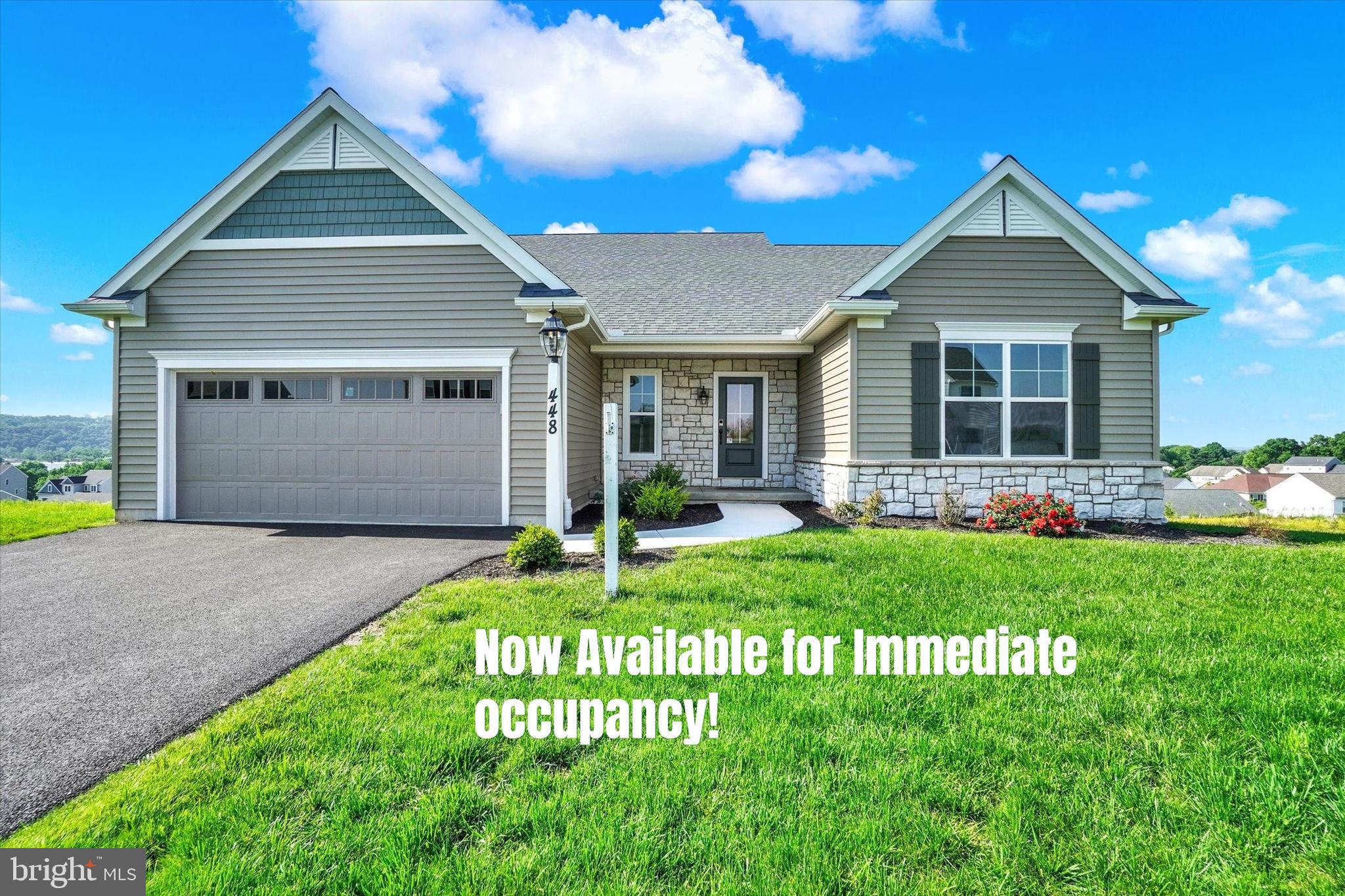 a front view of a house with a garden and yard