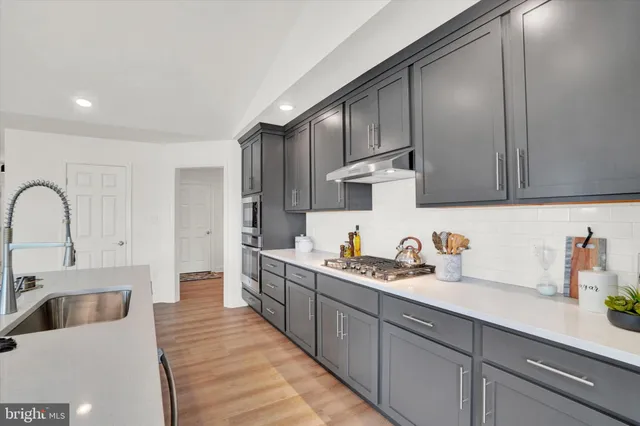 a kitchen with stainless steel appliances granite countertop a sink stove and refrigerator