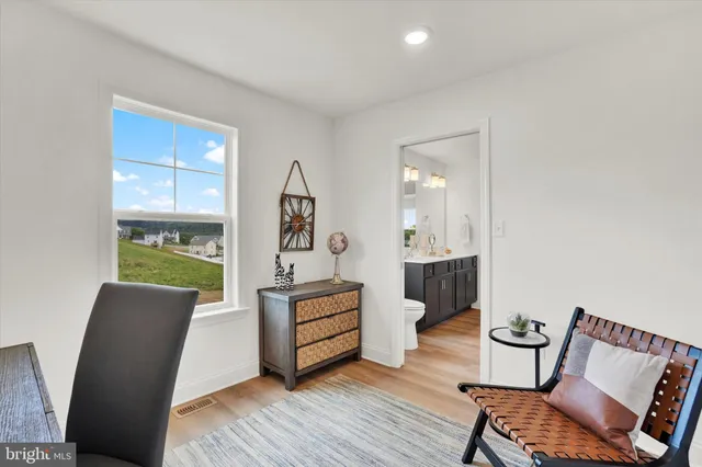 a view of a workspace with furniture and a window