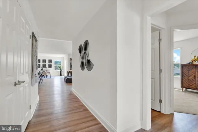 a view of a hallway with wooden floor windows and livingroom