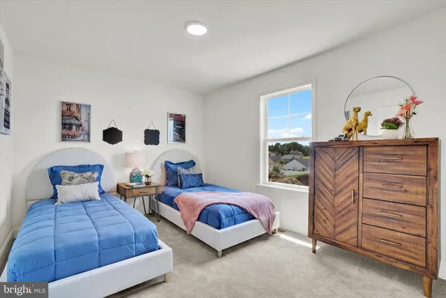 a bedroom with two beds and painting on the wall