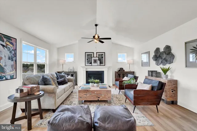 a living room with furniture a fireplace and a large window