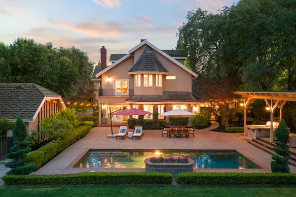 a view of a house with swimming pool and a garden